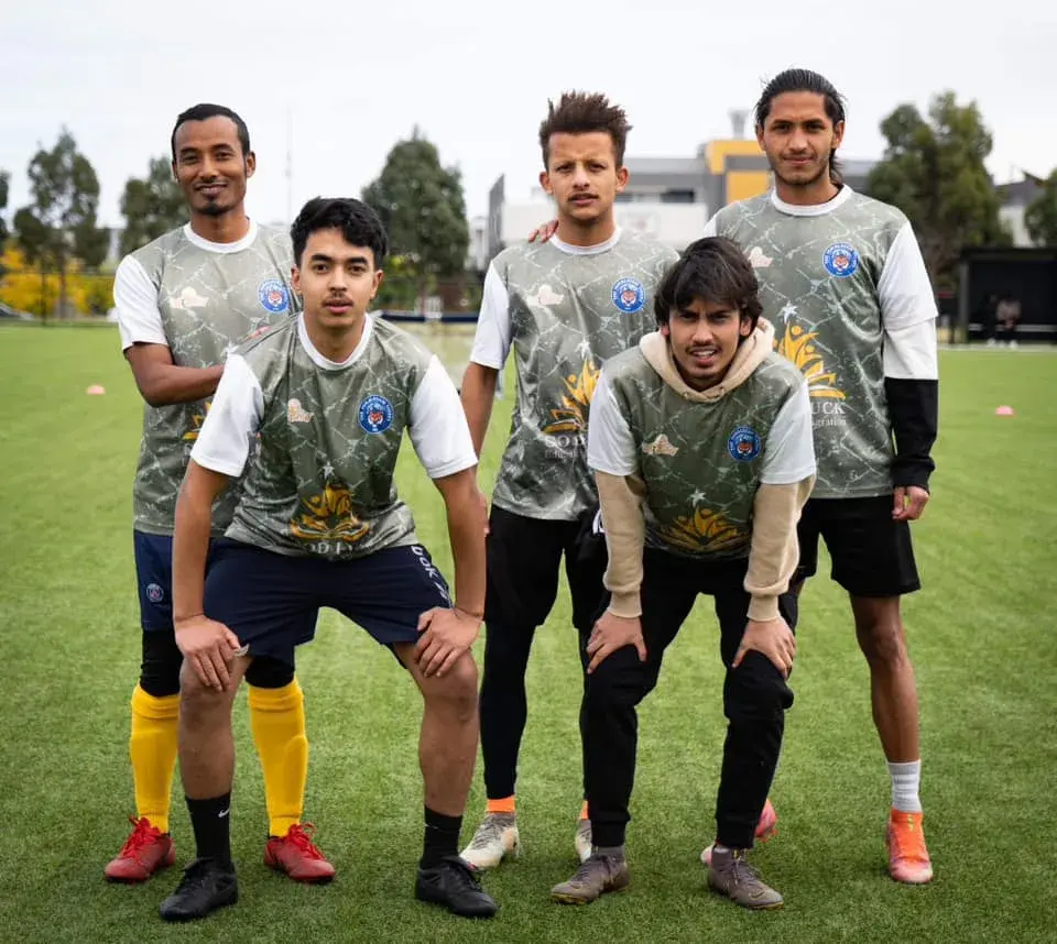 Players in grey kits posing together on the pitch