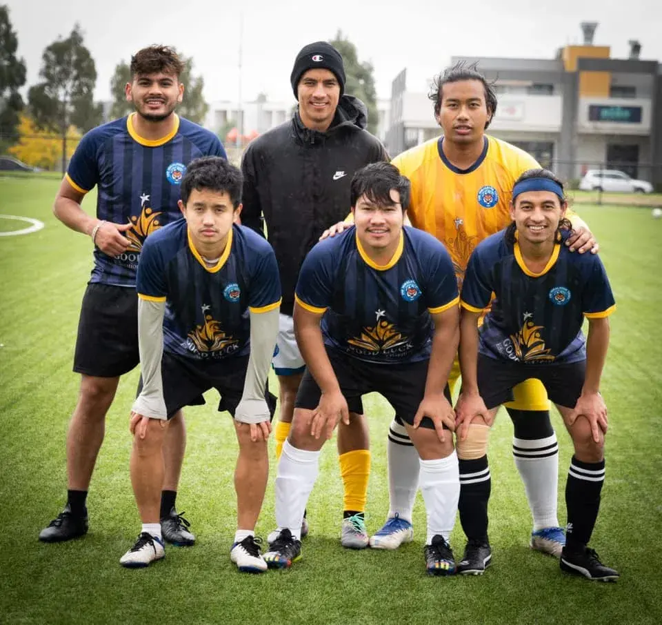 Players in navy and yellow kits posing together