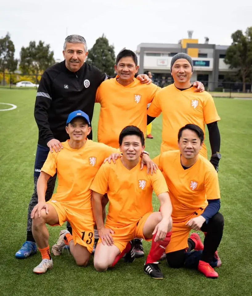 Players in orange kits posing with a football
