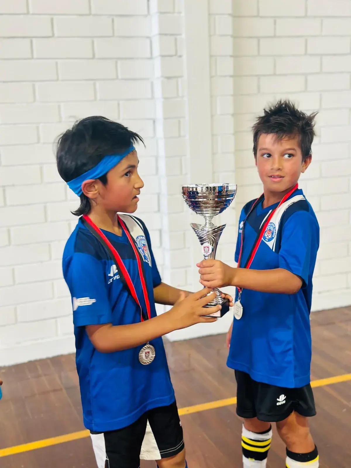 Two young players holding a trophy