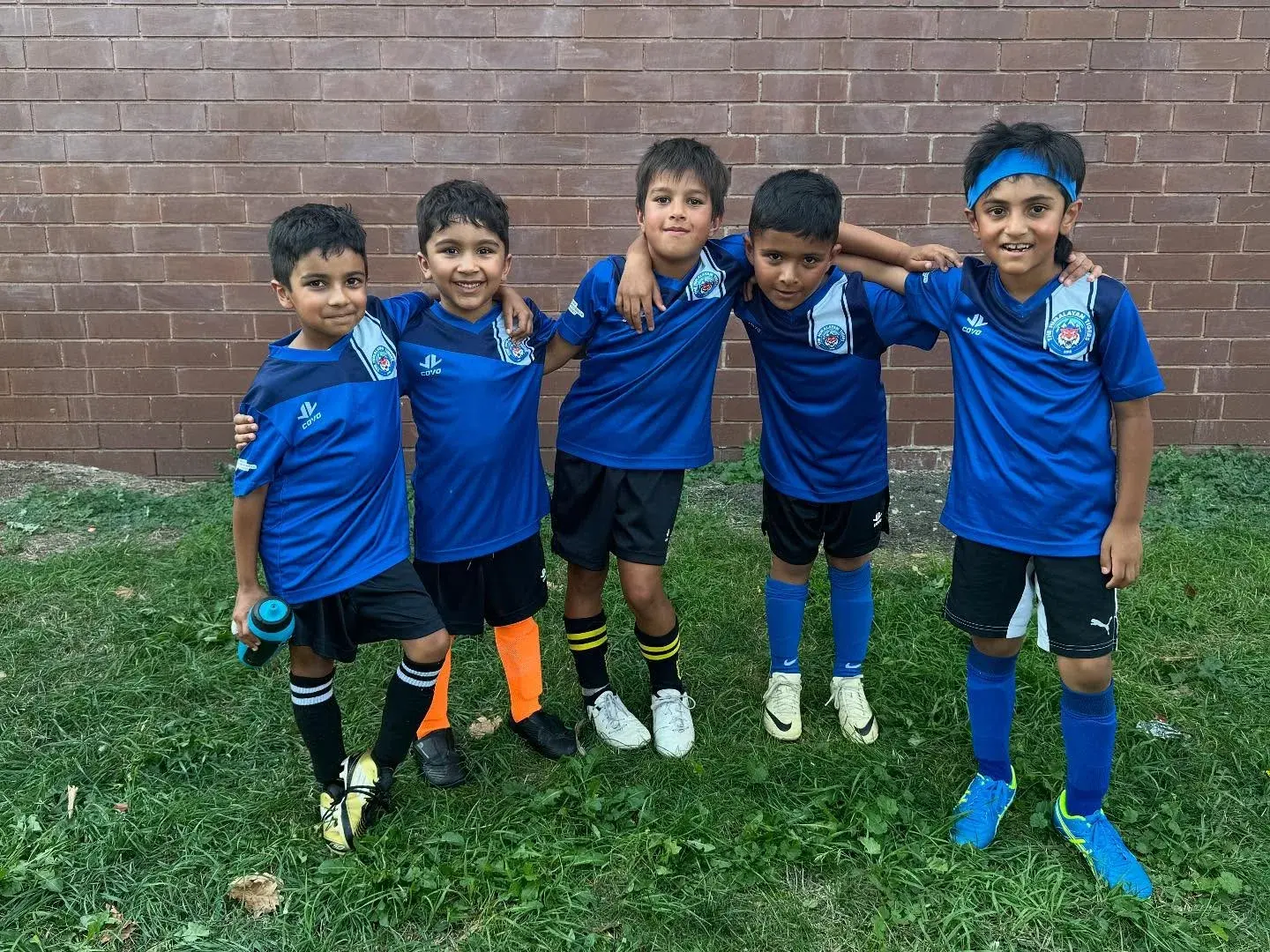 Young Tigers linking arms in their blue kits