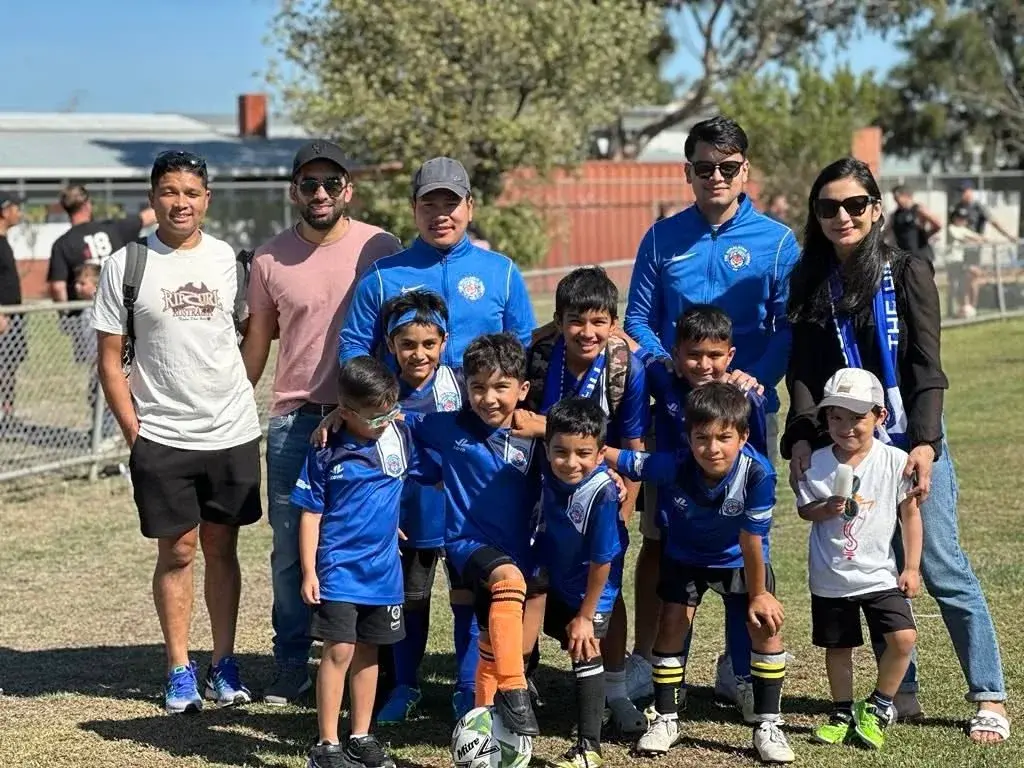 Young Tigers and coaches posing at the ground