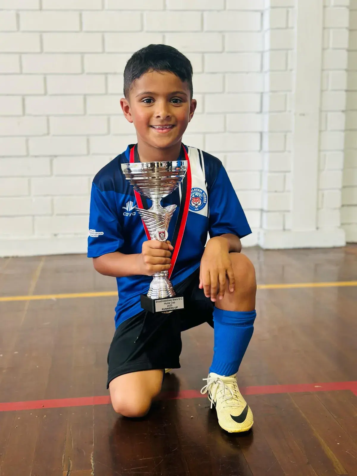 Young player wearing a medal and holding a trophy
