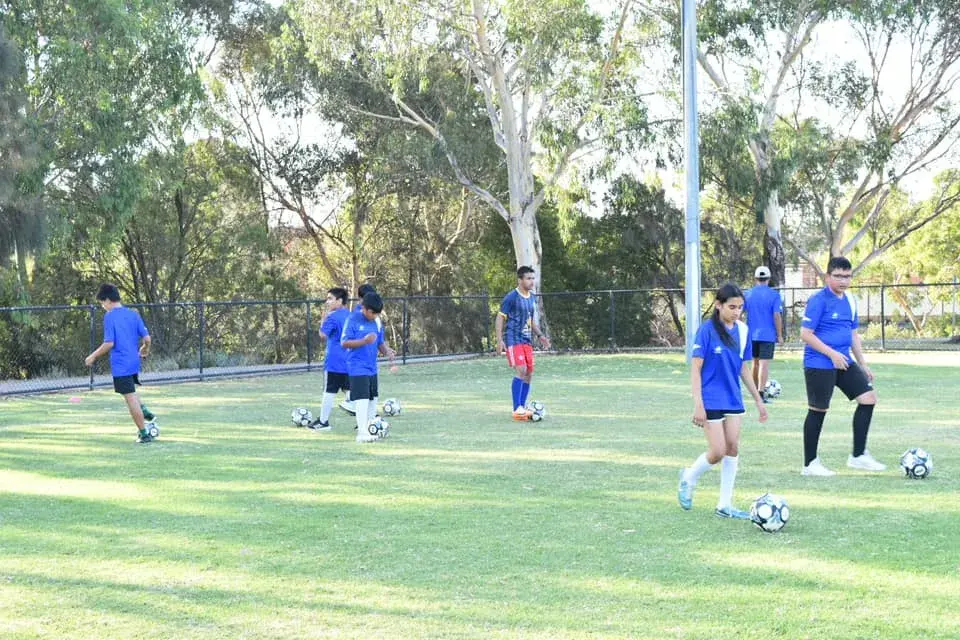 Children practising on the shaded pitch
