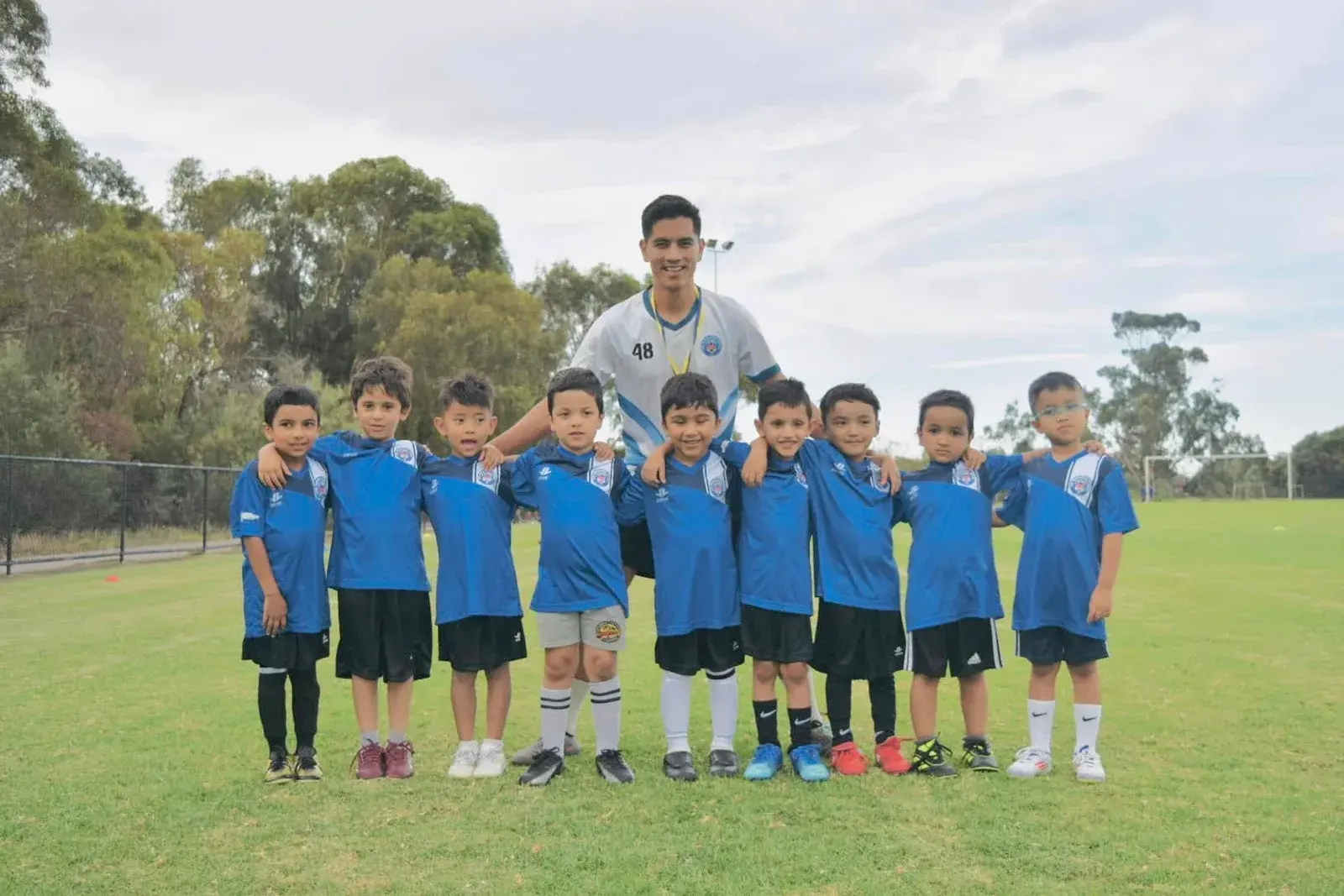 Academy players standing together in blue kits