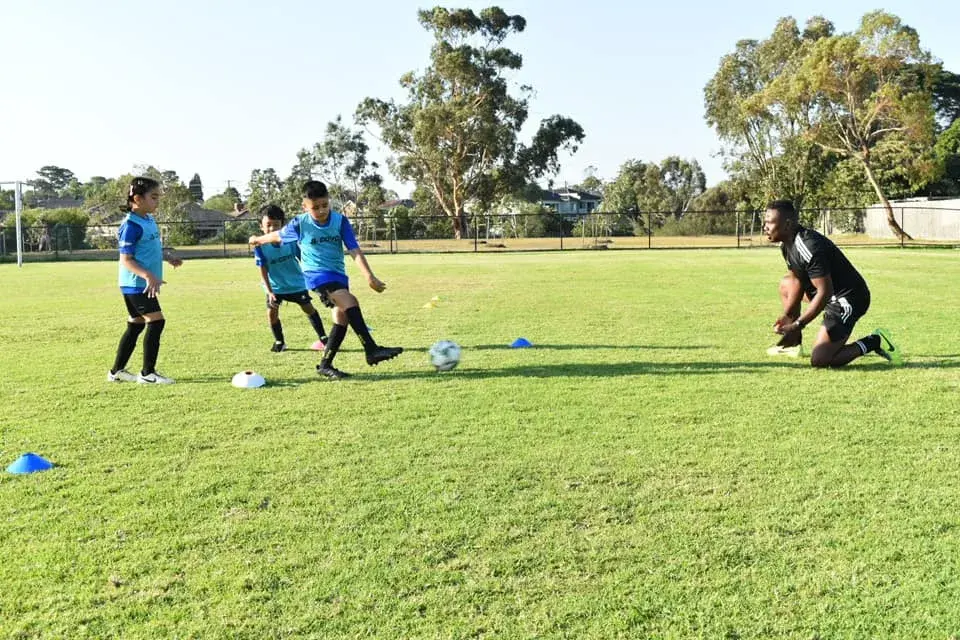 Coach and children practising passing