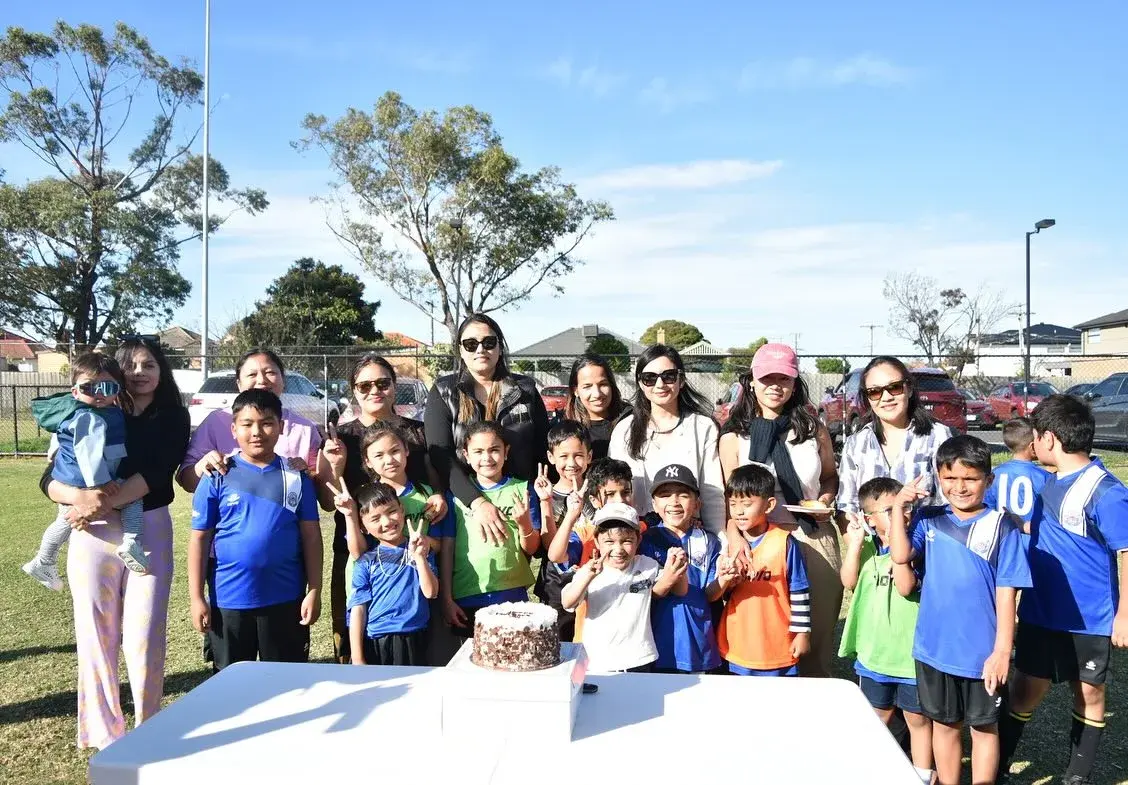Children and families gathered around the cake