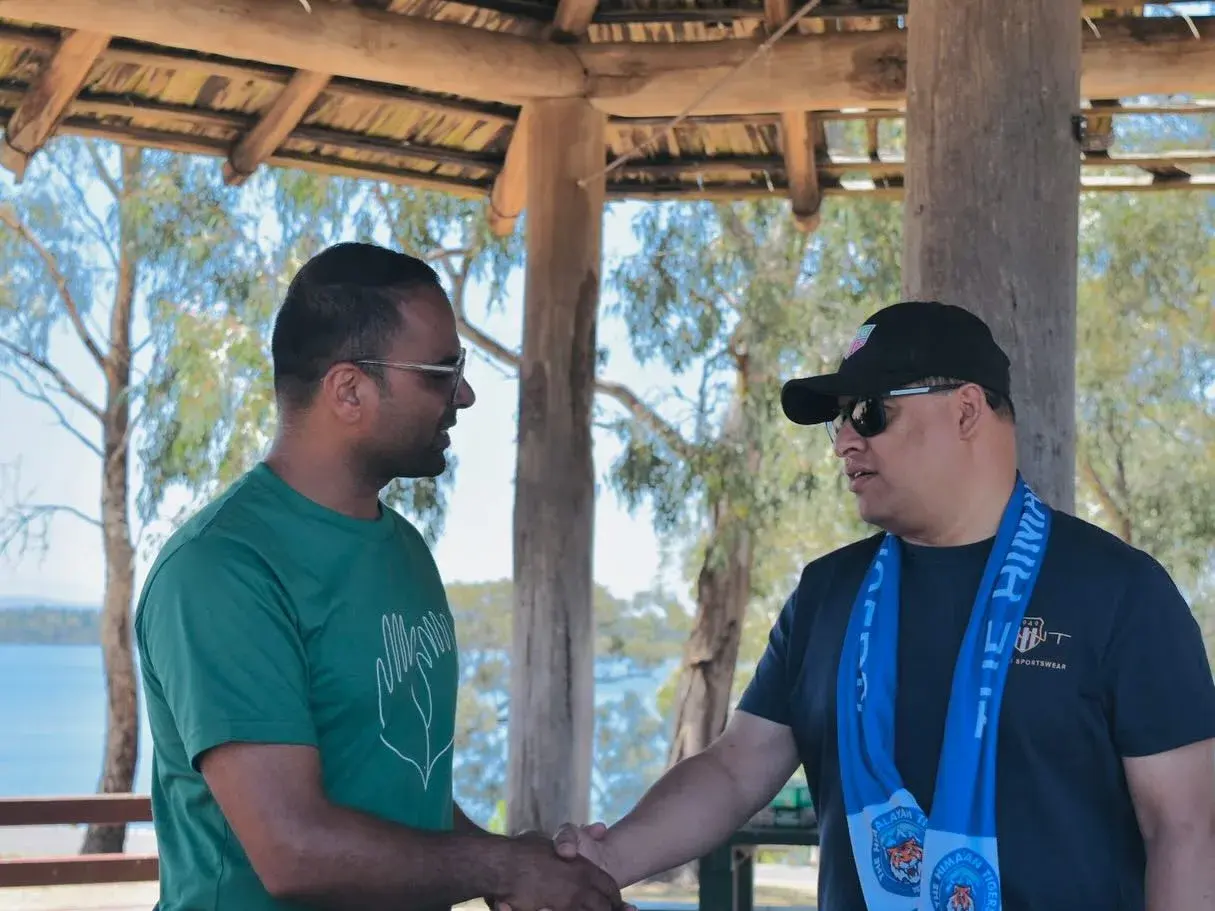 Club members greeting each other under a shelter