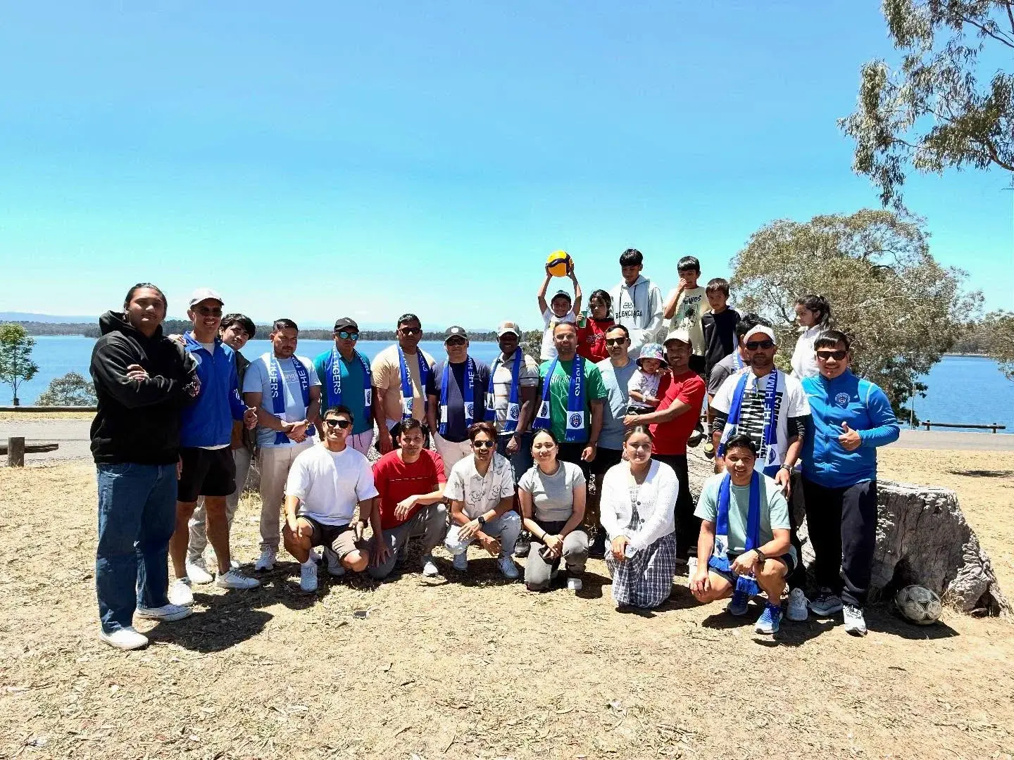 Club group posing together beside the water