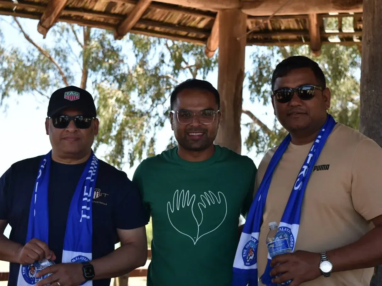 Three club members posing under the shelter