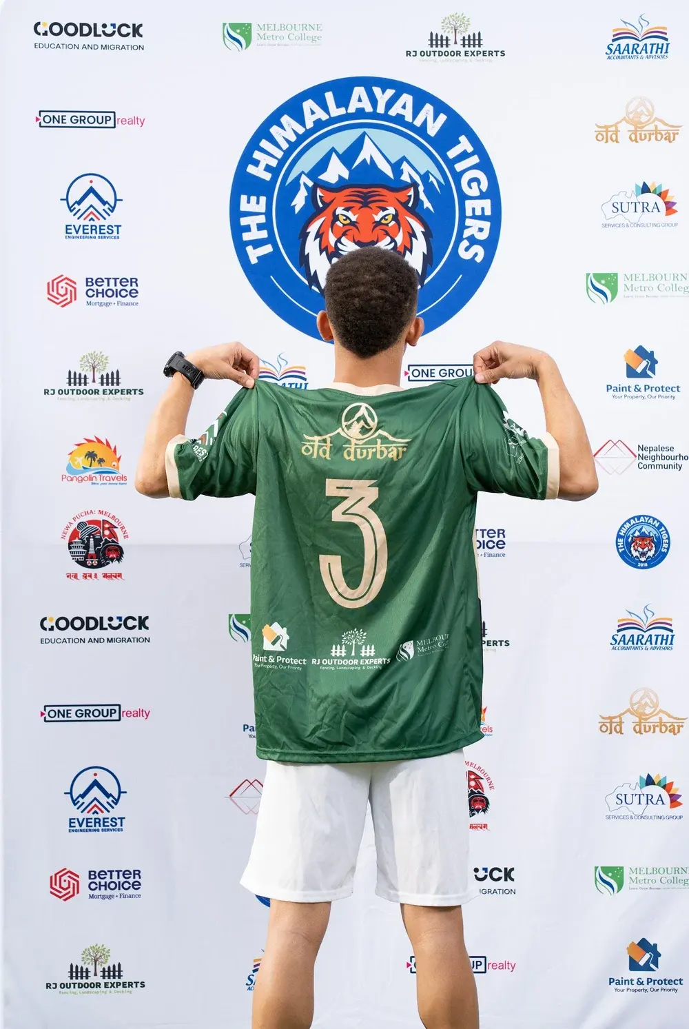 Player showing the back of the green Tigers jersey, with gold number 3 and sponsor details